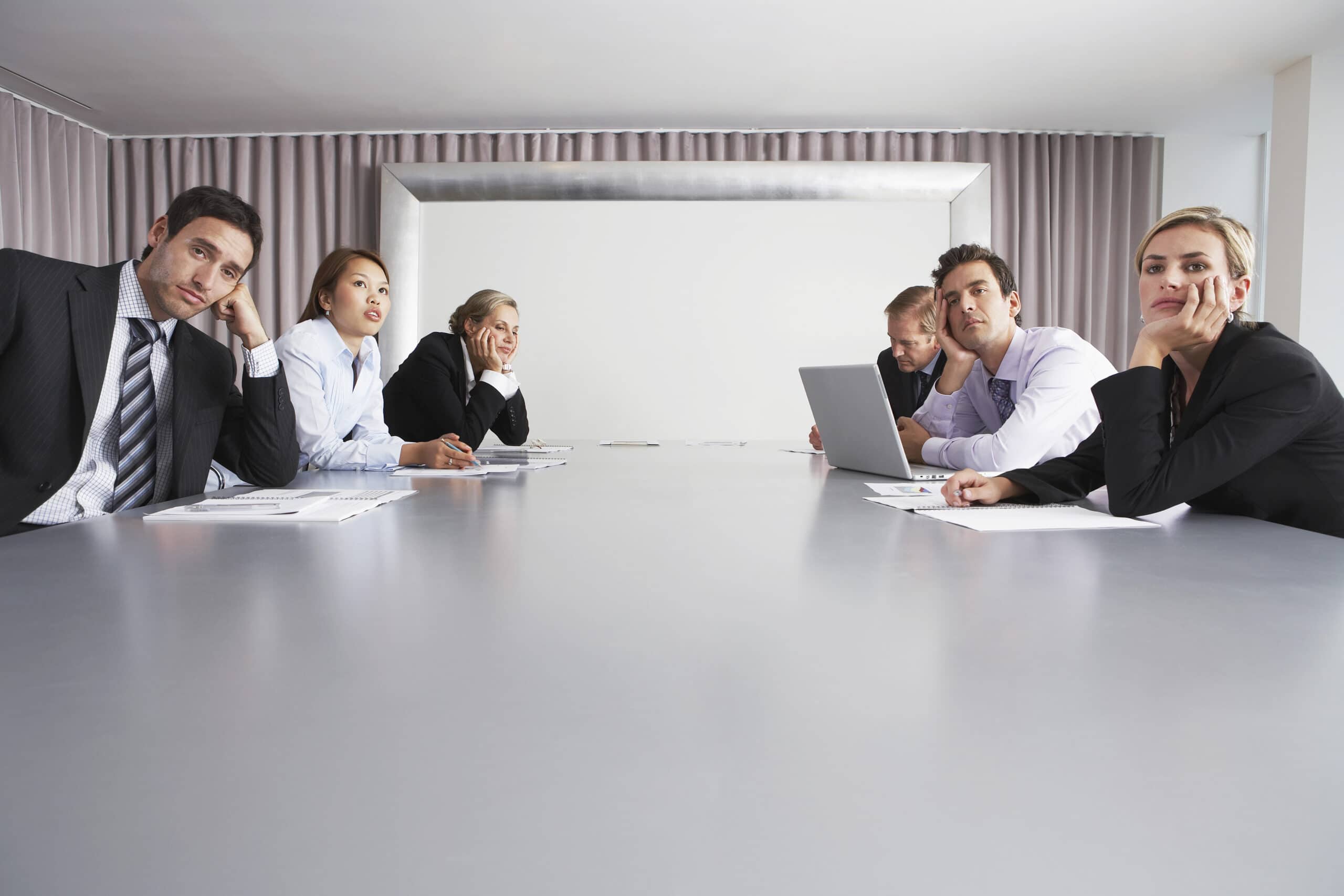 Bored multiethnic business people sitting in conference room