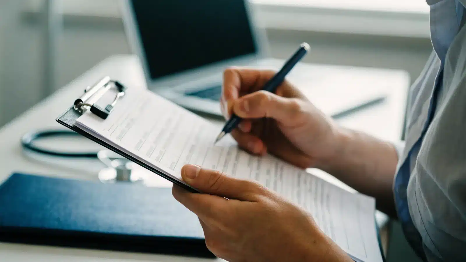 A health center administrator checks items on a printed board checklist on a clipboard